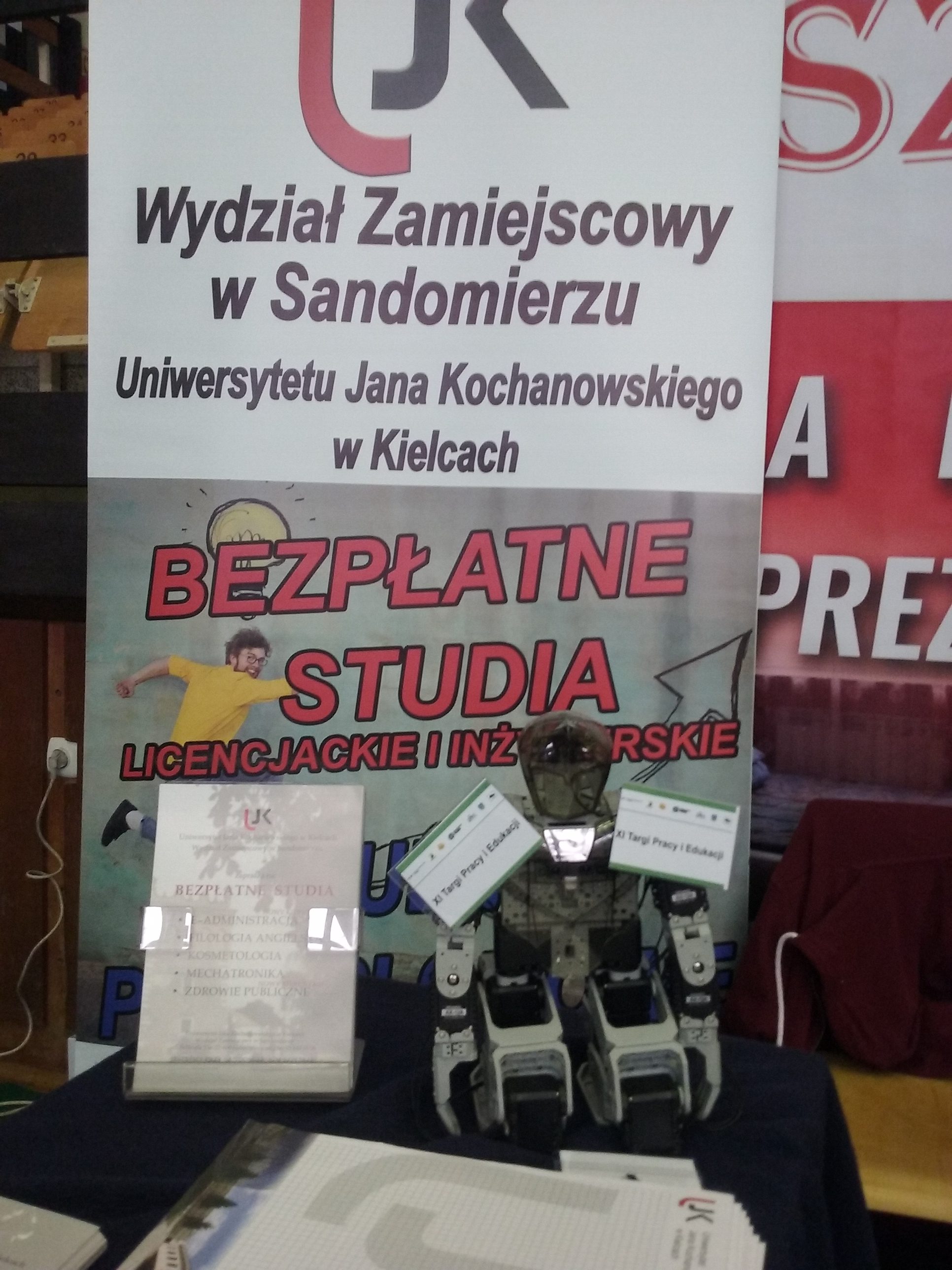 baner rekalmowy ujk typu standup na tle stanowiska na targach