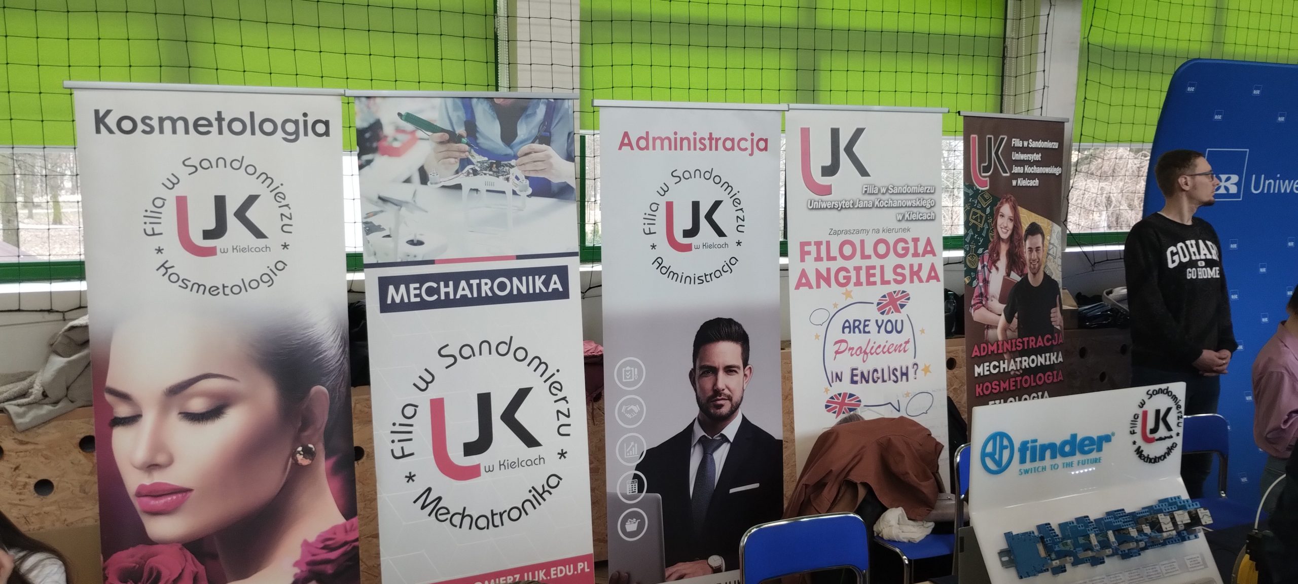 Studenci filii w sandomierzu na tle baneróow reklamowych kierunkow filologia angielska mechatronika kosmetologia administracja